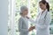 Nurse helping sick kid with cancer in headscarf in the hospital