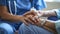 A nurse holding the hand of an elderly patient both with peaceful smiles on their faces. Despite the struggles and pain