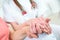 Nurse holding hand senior woman in wheel chair