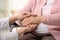 Nurse holding hands of elderly woman against blurred background. Assisting senior generation