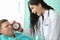 Nurse holds an alarm clock near patients face