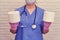 A nurse holds two rolls of white toilet paper. Doctor with a stethoscope with rolls of toilet paper in his hands, diarrhea concept