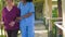 Nurse at the hospital helps elderly woman with walking handicap - Active seniors outdoor