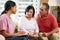 Nurse Making Notes During Home Visit With Senior Couple