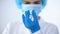 Nurse in mask holding bottle with vaccine, new drug research, illegal doping