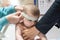 Nurse measuring the cranial perimeter of a baby in a clinic with a tape measure