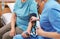 Nurse measuring senior woman`s blood pressure in hospital ward. Medical assisting