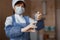 Nurse in medical clothes is about to be vaccinated to find in a hospital ward. Focus on the syringe, the woman`s face is blurred.