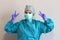 A nurse in a medical uniform with hygienic face surgical medical mask and gown, making a peace sign