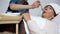 Nurse of mental hospital feeding indifferent woman with porridge, asylum