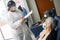 Nurse monitoring a senior adult patient to be aware of any adverse effects attributable to the vaccine after the application of th
