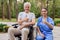 A nurse and an old man who sits in a wheelchair are showing a thumbs up