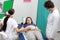 A nurse performs an ultrasound on a pregnant patient under the guidance of the attending doctor. Green screen.