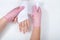 Nurse with pink gloves wrapping young girls hand with gauze dressing