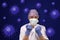 Nurse with protective gear  surrounded by corona virus makes fist