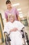 A Nurse Pushing A Senior Woman In A Wheelchair