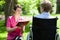 Nurse reading next to disabled woman