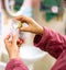 The nurse`s hands is pouring mother`s fresh milk from the bottle to medicine measuring glass cup for sick newborn baby