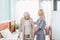 nurse and senior woman with walker smiling each other in hospital