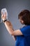 A nurse sets up a medical dropper. Medical worker on a gray background