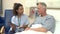 Nurse Sitting By Male Patient\'s Bed Using Digital Tablet