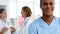 Nurse smiling and standing in front of medical team