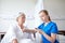 Nurse with stethoscope and senior woman at clinic