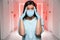 Nurse in surgical mask and gloves at hospital during pandemic virus outbreak, overwhelmed and stressed while emergency alert alarm