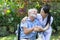 A nurse take care a senior male on wheelchair in his garden at home