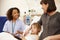 Nurse Talking To Mother And Daughter In Hospital Bed