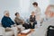 Nurse is talking to new patients sitting on the sofa in a retirement home