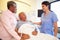 Nurse Talking To Senior Couple In Hospital Room