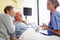 Nurse Talking To Senior Couple In Hospital Room