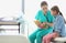 Nurse teaching child patient how to check heartbeat with teddy bear at hospital