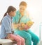 Nurse teaching child patient how to check heartbeat with teddy bear at hospital