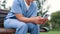 Nurse, typing and cellphone on bench in park, outdoor and internet connection for networking in city. Healthcare