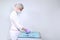 A nurse in a uniform and medical mask lays out sterile dental instruments Packed in a Kraft bag. Gloved hand. Copy of the space.