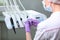 A nurse in uniform and a medical mask wipes the dental unit. Back view. Gloved hand.Disinfection in the dental office. Copy of the