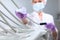 A nurse in uniform and wearing a medical mask wipes dental equipment. The face is out of focus. Gloved hand. Disinfection in the