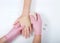 Nurse wearing pink gloves wrapping young girls hand with ace bandage