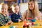 Nursery children playing with teacher in the classroom