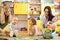 Nursery children playing with teacher and helper in the classroom