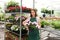 Nursery owner showing a flowering potted impatiens