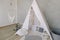 Nursery in Scandinavian style. Scandi child room interior in real photo. Decorative boho styled hut, tipi, wigwam