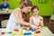 Nursery teacher and girl playing