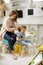 Nursery teacher helping little girl to fix hair in the kindergarten playroom