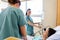 Nurses Examining Patient In Hospital