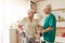 Nursing assistant helping senior woman with walking frame