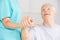 Nursing assistant holding hand of senior man