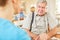 Nursing woman consoles senior man in home